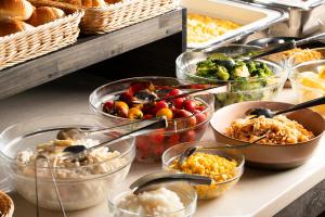 a buffet with many bowls of food on a table at L stay & grow Minami Sunamachi in Tokyo