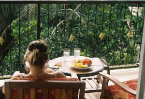 a girl sitting at a table with a plate of food at Kandyan View Homestay - Foreign in Kandy