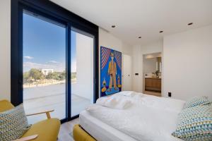 Un dormitorio con una cama y una ventana grande. en 2HomeRent Las Colinas, en Orihuela Costa 114 fotos más