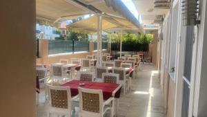 a restaurant with a red table and white chairs at Dalyan Vira Hotel in Ortaca
