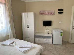 a bedroom with a bed and a white refrigerator at Dalyan Vira Hotel in Ortaca