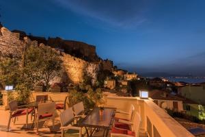 een tafel en stoelen op een balkon met uitzicht op de stad bij Amfitriti Palazzo in Nafplio