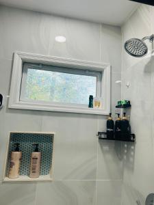 a bathroom with a window and a shower at Fancy Studio Private Entrance in Selden