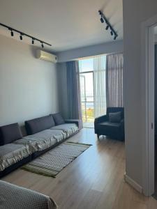 una sala de estar con un sofá y una silla en Gio, en Batumi 61 fotos más
