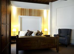 a bedroom with a bed and a blue chair at Hotel U Kříže in Prague