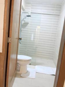 a bathroom with a shower and a toilet with towels at Villa súper cómoda 3 habitaciones con piscina in Juan López
