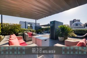 Un patio con sofás y mesas en una azotea. en AR 218 Hotel by ULIV, en Ciudad de México