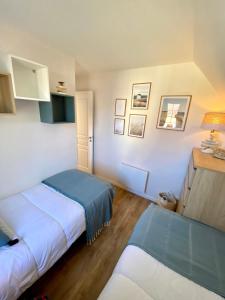 a small bedroom with two beds and a table at Le Cottage de Belle Dune in Fort-Mahon-Plage