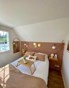 a bedroom with a bed with a table on it at Le Cottage de Belle Dune in Fort-Mahon-Plage