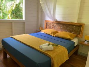 Cottage Ô Cœur de Bel Hâlé في سانت-روز: غرفة نوم بسرير ازرق مع نافذة +19 صورة