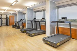 a gym with several treadmills and elliptical machines at Crowne Plaza Milan Linate by IHG in San Donato Milanese