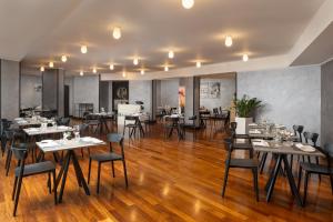 a restaurant with wooden floors and tables and chairs at Crowne Plaza Milan Linate by IHG in San Donato Milanese