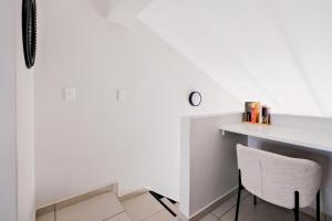Habitación con escritorio blanco y silla en Peaceful Fourways Loft Apartment, en Sandton