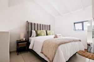 Un dormitorio con una cama con un animal de peluche encima. en Peaceful Fourways Loft Apartment, en Sandton 7 fotos más