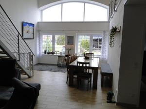 a dining room and living room with a table and chairs at Ferienwohnung Sonnenaufgang im Ruppiner Land in Kränzlin