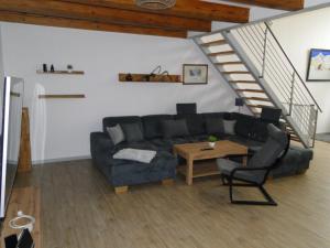 a living room with a couch and a table at Ferienwohnung Sonnenaufgang im Ruppiner Land in Kränzlin