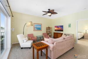 a living room with a couch and chairs and a ceiling fan at Stay ON Flagler Avenue! Charming Condo with Full Kitchen, Parking and Courtyard! in Chicken Island