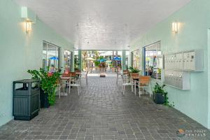 an empty hallway with tables and chairs in a building at Stay ON Flagler Avenue! Charming Condo with Full Kitchen, Parking and Courtyard! in Chicken Island