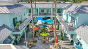 an aerial view of the courtyard of a resort with tables and umbrellas at Stay ON Flagler Avenue! Charming Condo with Full Kitchen, Parking and Courtyard! in Chicken Island