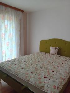 a bedroom with a bed with a green headboard at Villa Ena in Sarajevo