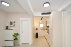 多布罗塔SEA VIEW apartment 2km from the Old Town of Kotor的厨房拥有白色的墙壁和白色的天花板