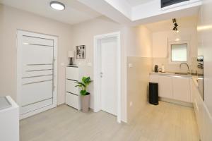 多布罗塔SEA VIEW apartment 2km from the Old Town of Kotor的白色的厨房设有水槽和门 更多37张照片