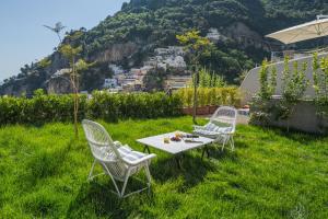 two chairs and a table in the grass at Villa Romito - Sea view, central location in Positano +65 photos