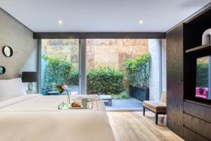 Un dormitorio con una cama y una ventana grande. en AR 218 Hotel by ULIV, en Ciudad de México