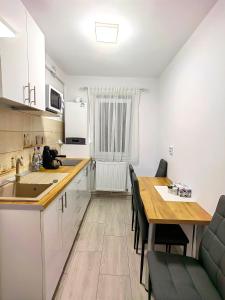 a kitchen with a wooden table and a dining room at Honey apartment in Tîrgu Ocna