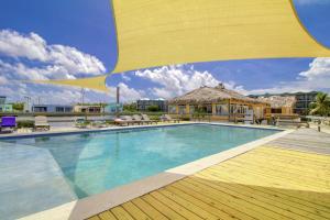 una piscina con una gran sombrilla amarilla encima en Suite F203 @ Mara Laguna, en San Pedro
