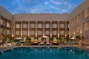 a hotel with a swimming pool in front of a building at Park Inn By Radisson Amritsar Airport in Amritsar