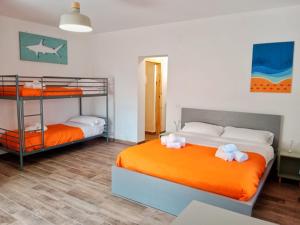 a bedroom with two bunk beds with orange sheets at Brezza Marina Studios in Montesilvano