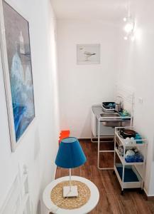 a table with a blue lamp in a room at Brezza Marina Studios in Montesilvano