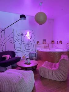 a living room with purple lighting and a tub at Mini loft Spa - Cosy in Dijon +27 photos