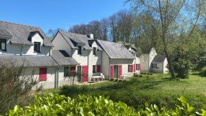 奎恩val Queven的一排带红色门的白色房屋