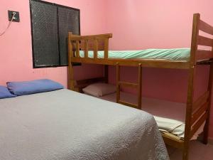 ein Schlafzimmer mit zwei Etagenbetten und einem Bett in der Unterkunft Residencial Romulo Casa in Manaus