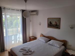 a bedroom with a bed and a large window at Geri Apartment in Ksamil