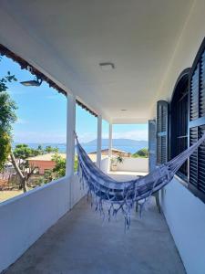a hammock on a porch with a view of the ocean at Linda Casa Com Vista Para a Praia! in São Pedro da Aldeia