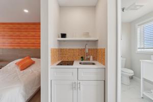 a white bathroom with a sink and a bed at The Voyager in Old Orchard Beach +33 photos