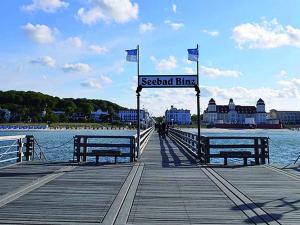 a wooden pier with two benches and flags on it at Villa Strandblick Binz in Binz