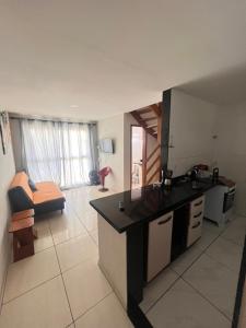 Una cocina con encimera y una sala de estar. en Apartamento na Orla da Praia Grande para até 6 pessoas - Arraial do Cabo, en Arraial do Cabo