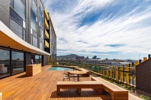 a balcony with a table and benches on a building at Amazing Views in the WEX in Cape Town