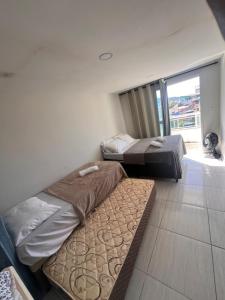 Dos camas en una habitación con ventana. en Apartamento na Orla da Praia Grande para até 6 pessoas - Arraial do Cabo, en Arraial do Cabo 11 fotos más