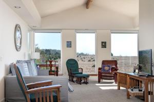 a living room with a couch and chairs and windows at Ocean Ranch Retreat Monthly Rental in Cambria