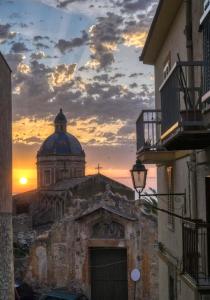 a view of a church with a sunset in the background at La Cupola - casa vacanze n 8 in Termini Imerese