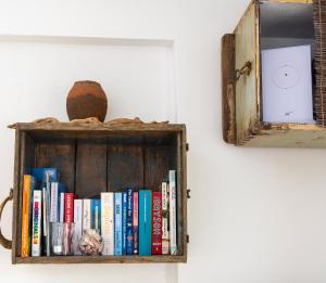 a book shelf with books and a mirror at Kastellas' Dream in Kithnos