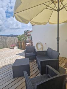 a patio with chairs and an umbrella on a deck at Vivenda do Calvario in Alvarães