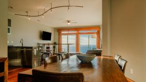a kitchen and dining room with a large wooden table at Chimmi House - Waterfront 3-Bedroom, 3-Bathroom Suite at REAL Watersports in Waves +26 photos