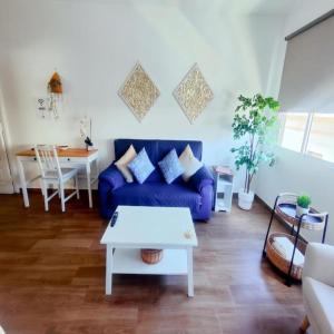 a living room with a blue couch and a table at Escapada Deluxe con Wifi 2 Hab 2 Baños con Cocina & SmartTV cerca de Todo in Santa Cruz de Tenerife
