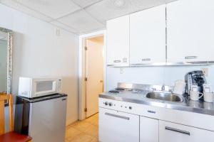 a kitchen with a sink and a microwave at Sea View Inn in Old Orchard Beach